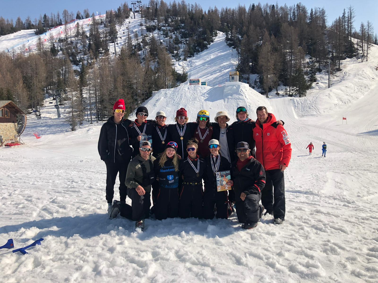 dea athlètes canadiens posent en groupe devant une montagne.