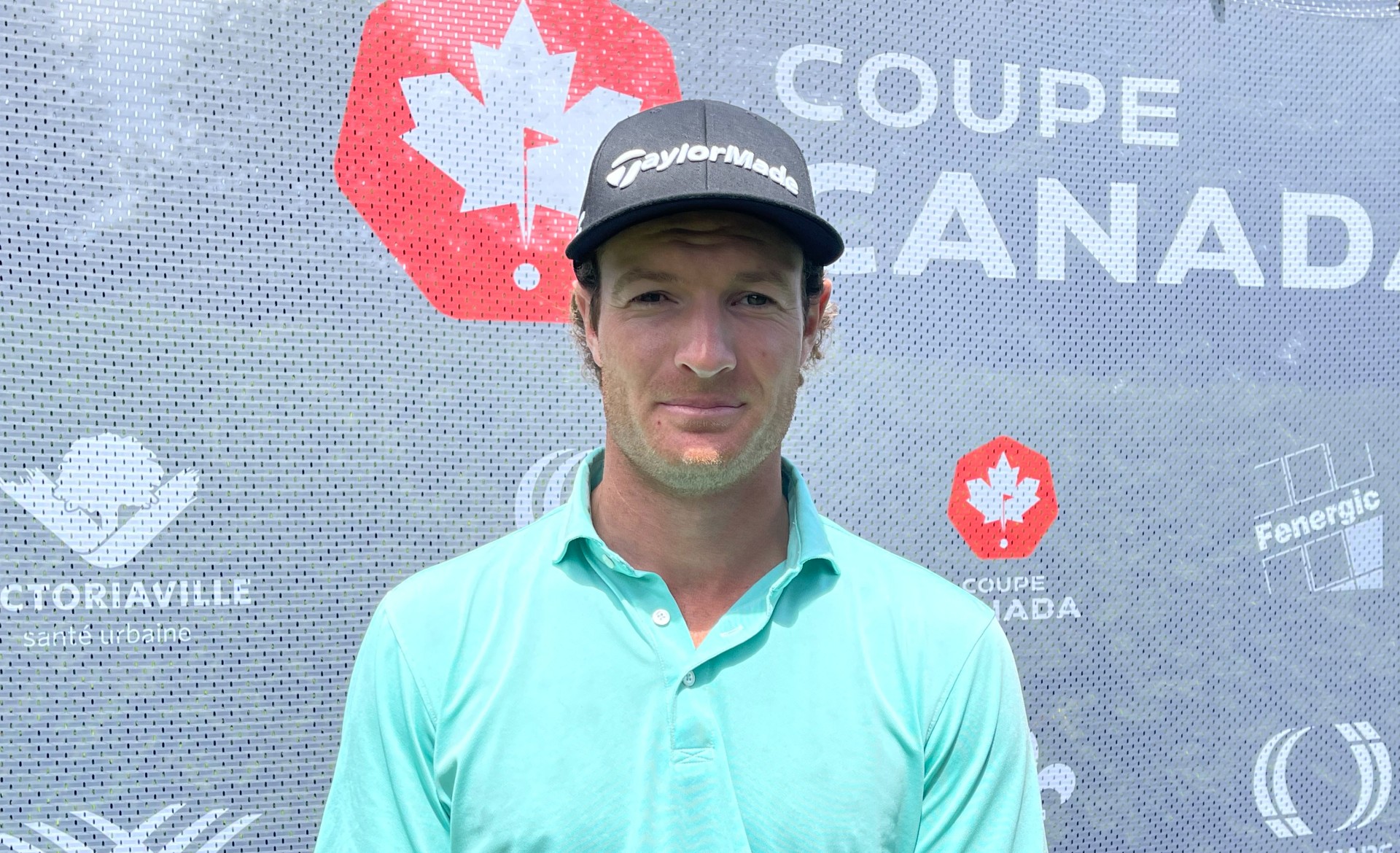 Un golfeur devant le logo de la Coupe Canada.
