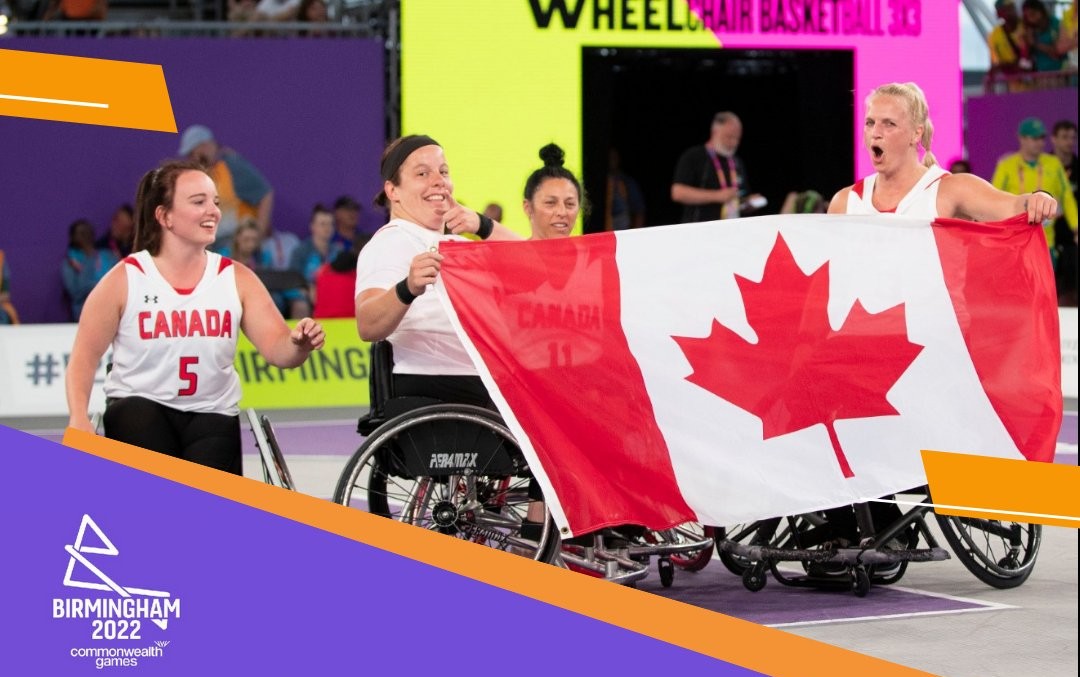 Des athlètes éfminines en fauteuil célèbrent avec le drapeau canadien.