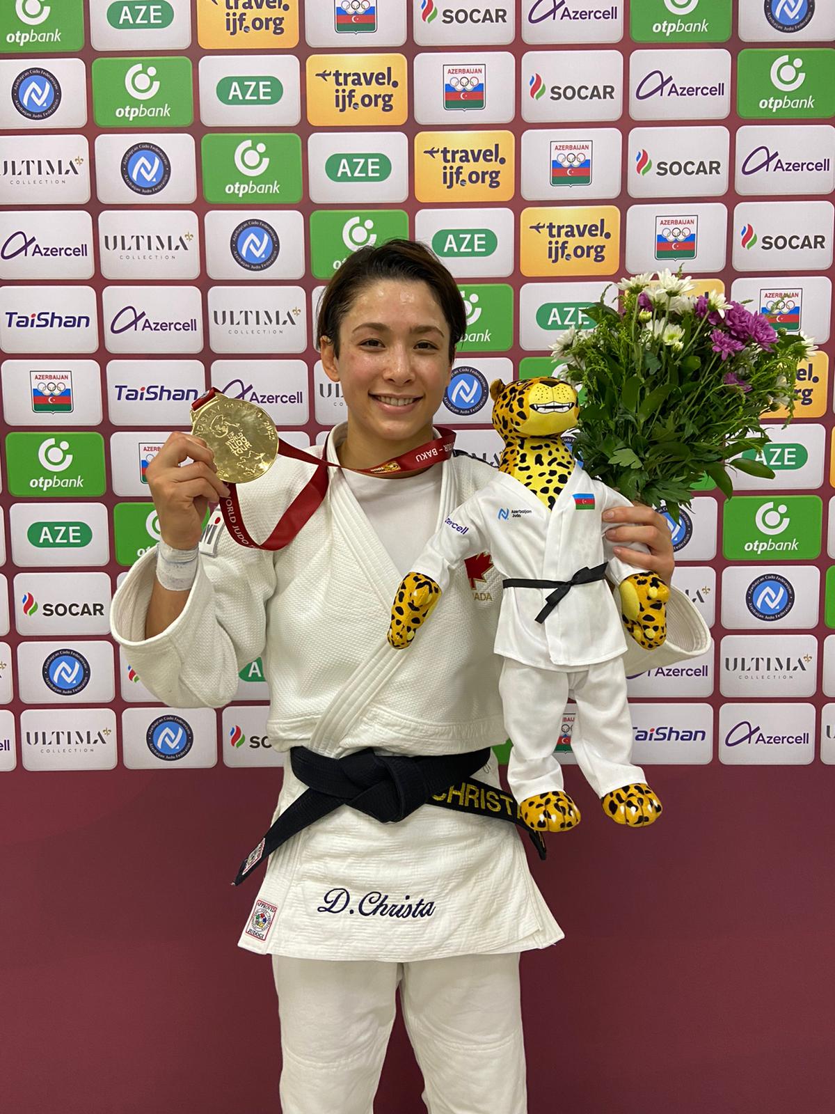 Une judoka souriante avec sa médaille.