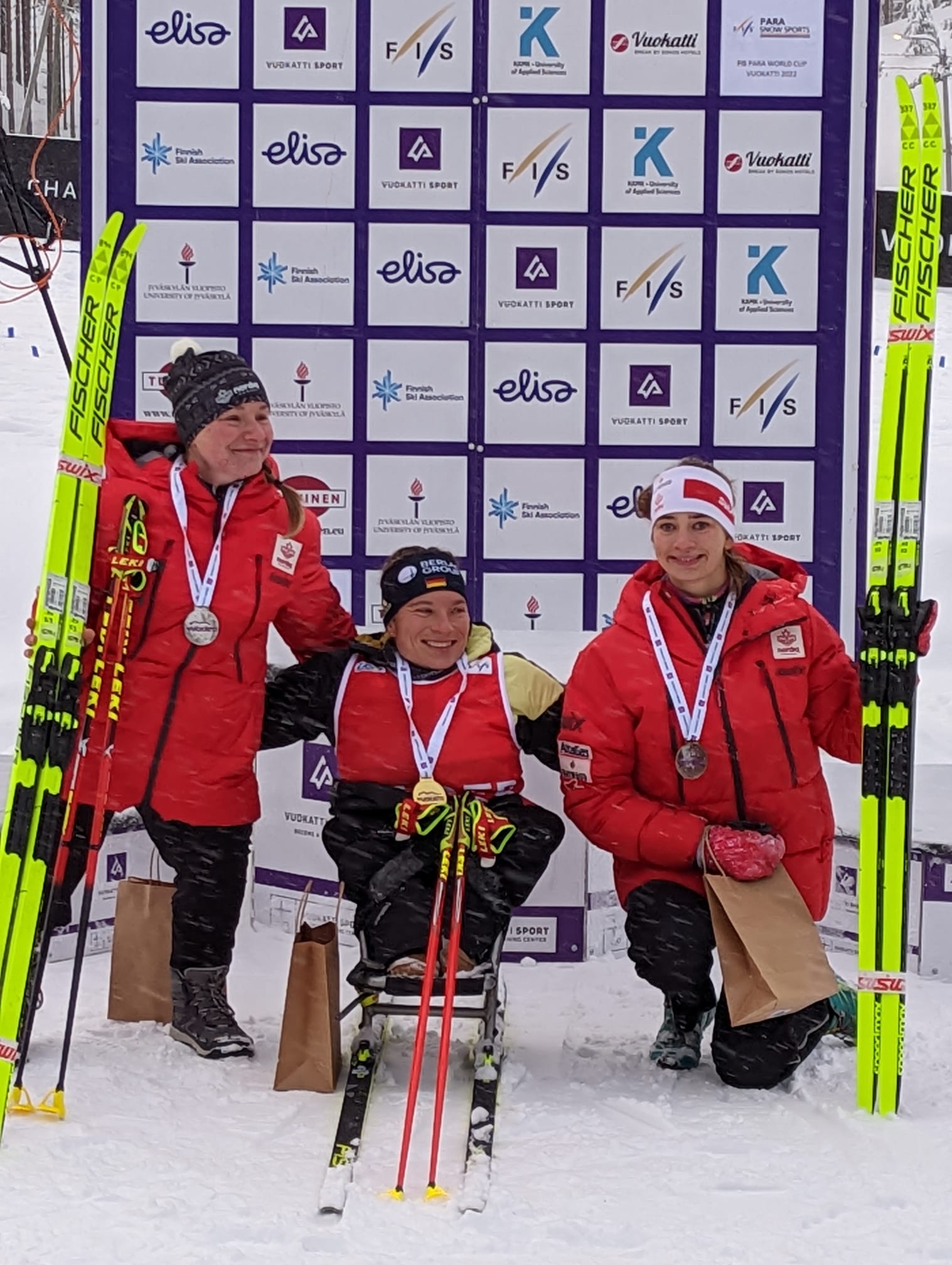 Trois skieuses paranordique souriantes avec leur médaille.