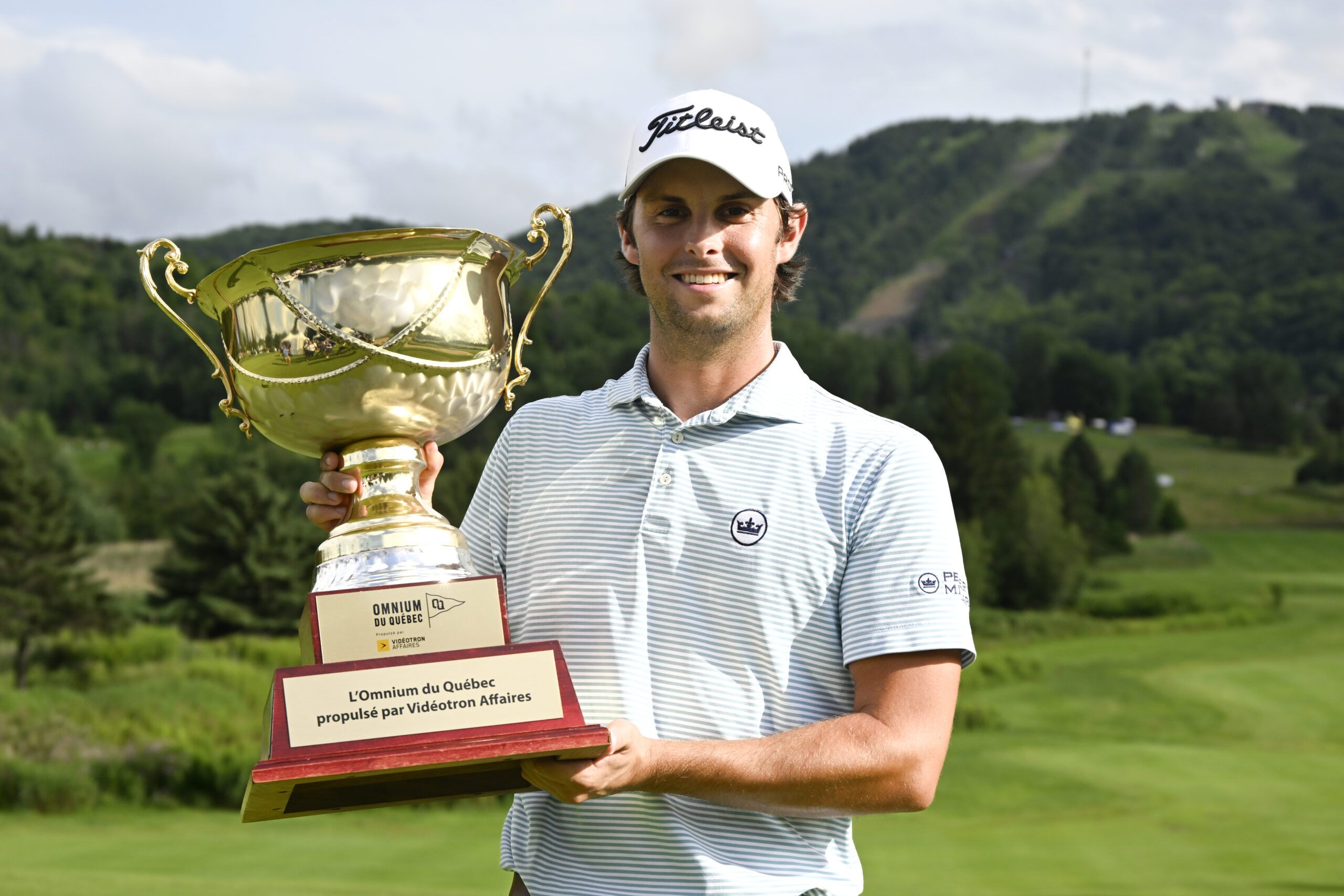 Un golfeur souriant avec son trophée.