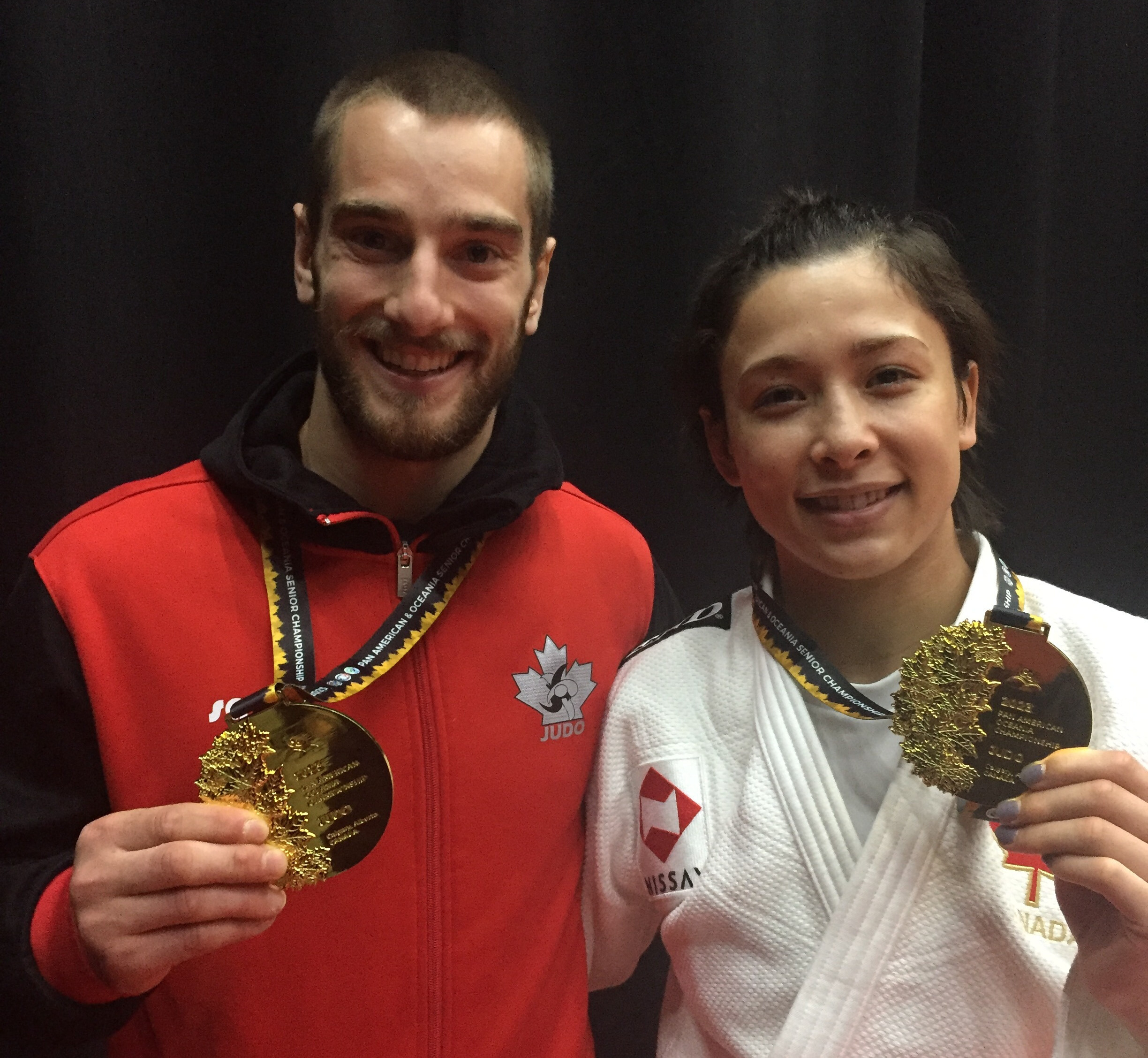 Deux athlètes canadiens souriants avec leur médaille d'or.